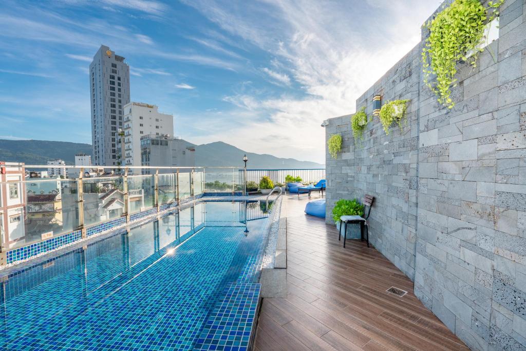 Rooftop pool at Cani Beach House, with the sea and a mountain beyond the glass railing