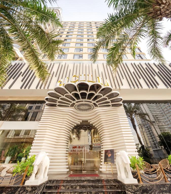 Cicilia Danang Hotels & Spa tower with the CICILIA sign, palms and the street in front