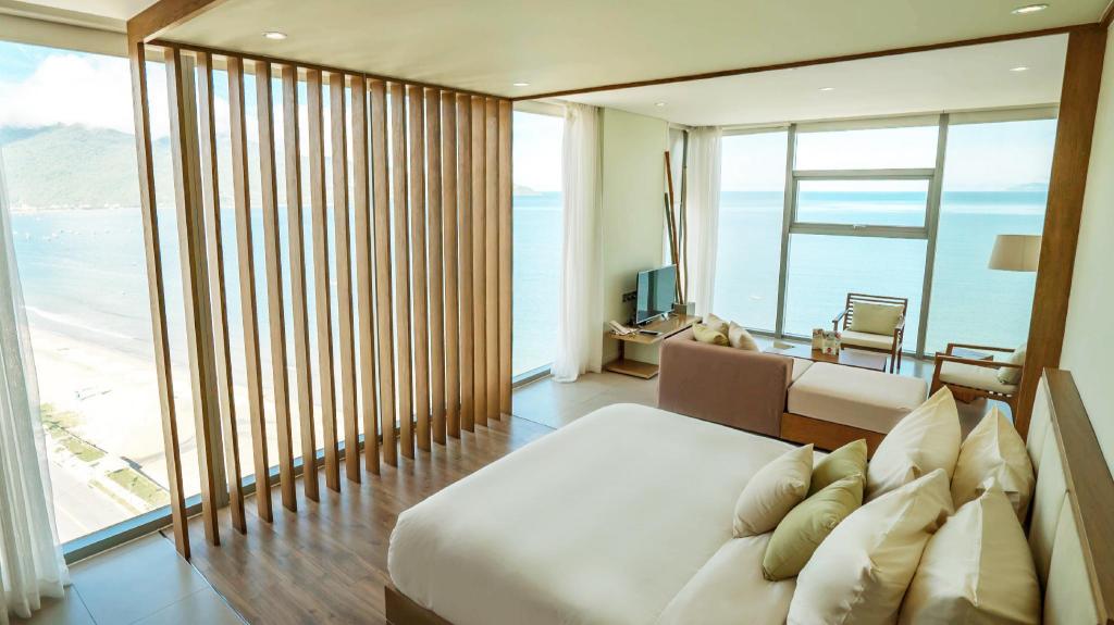 Family suite bedroom with two beds, a white headboard and a glass door onto a balcony