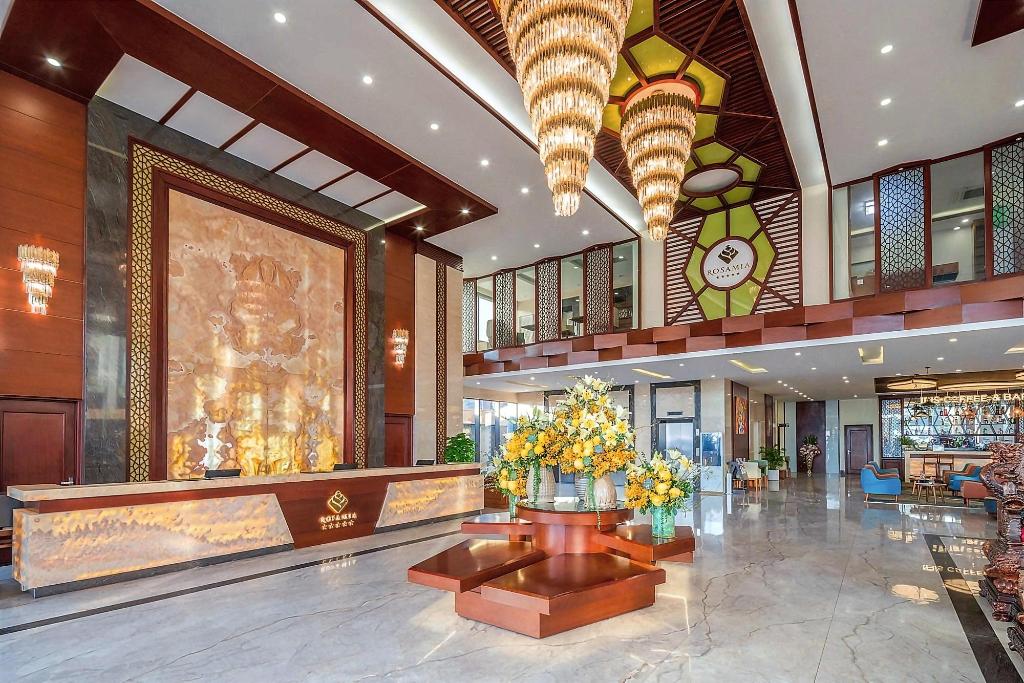 Double-height lobby at Rosamia Da Nang Hotel, with a seating area, reception desk and chandelier