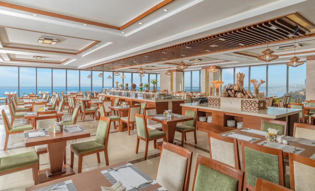 Restaurant at Rosamia Da Nang Hotel, with set tables, a buffet counter and a view through the windows