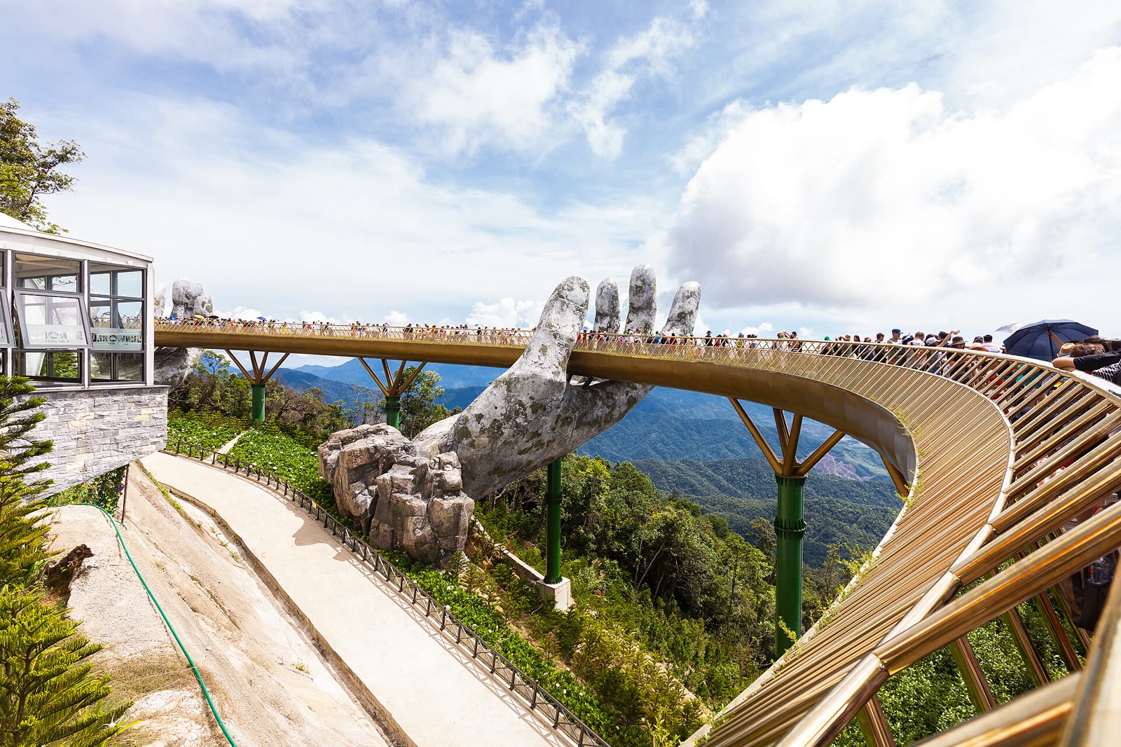 The Golden Bridge at Ba Na Hills, a gold walkway held up by two giant stone hands above the forest