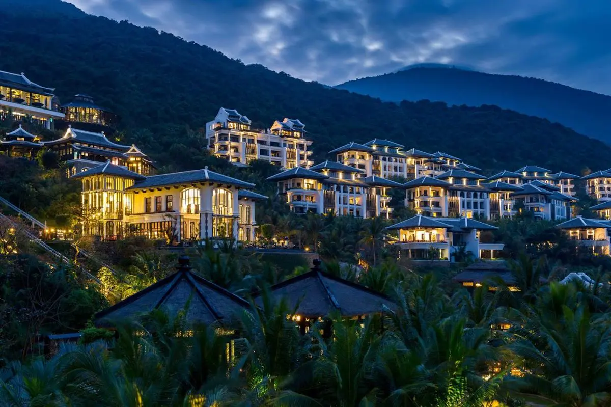 InterContinental Danang Sun Peninsula Resort at dusk, villas on the forested Son Tra hillside